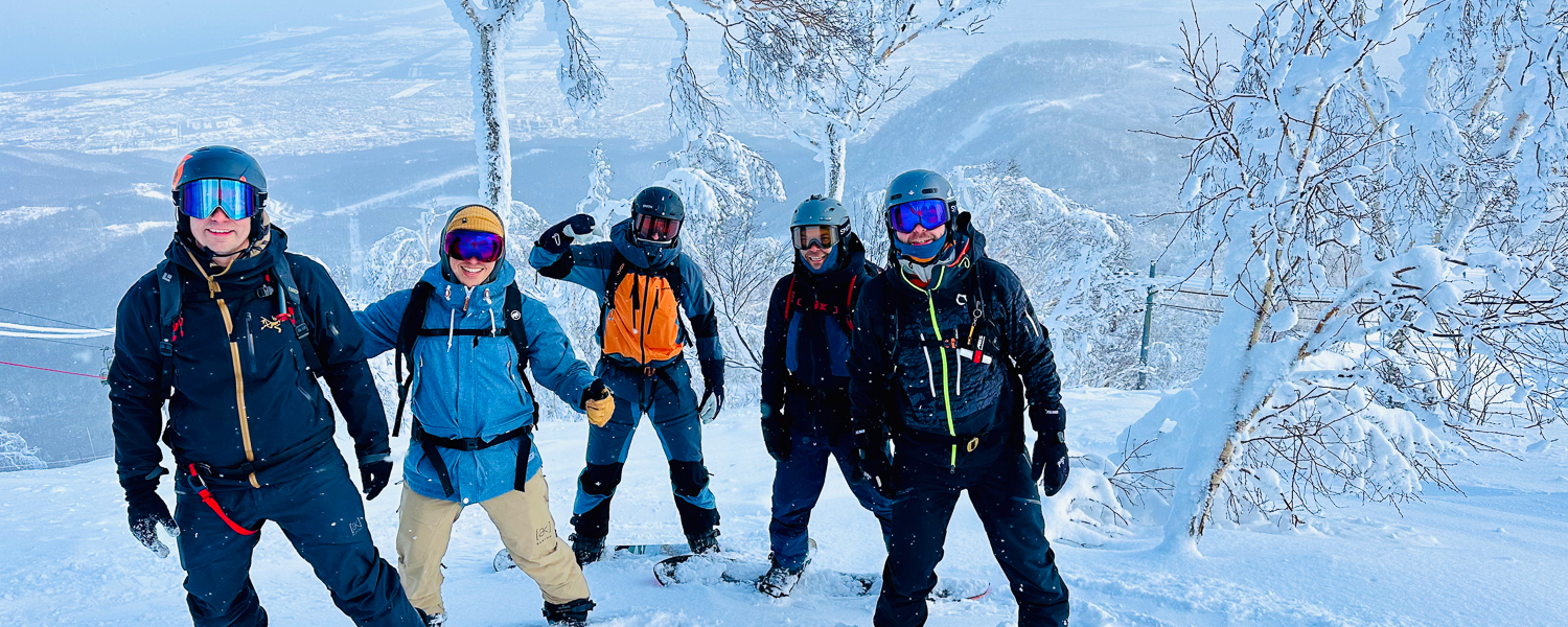 Guided snowboarding group exploring Hokkaido's untouched backcountry terrain